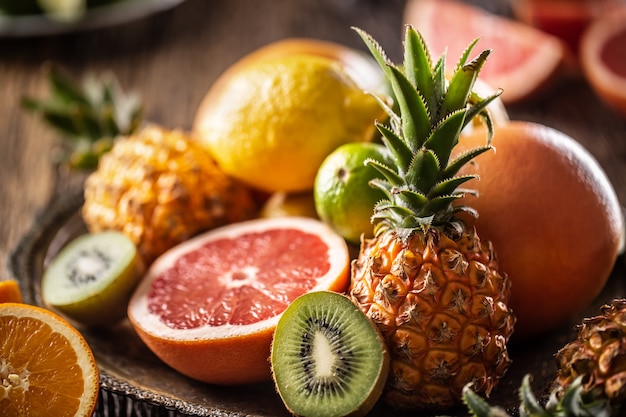 Assortment of fresh exotic fruit ideal for detox on a rustic wood surface.