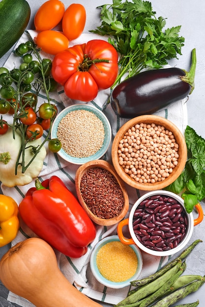 Assortment of fresh fruits and organic multicolored rainbow vegetables on gray concrete background. Food cooking and healthy clean food background and mock up.