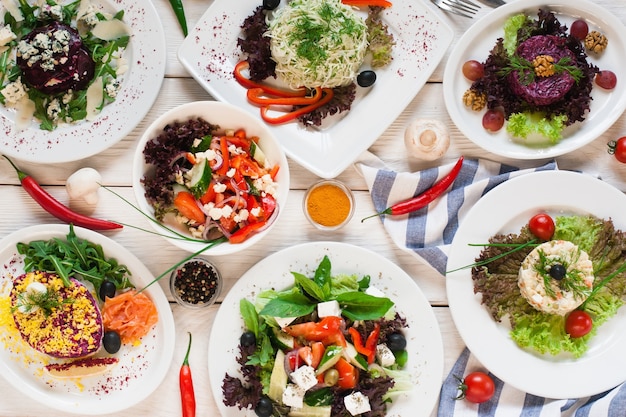 Assortment of fresh vegetable salads flat lay. top view on vegetarian buffet with tasty side dish