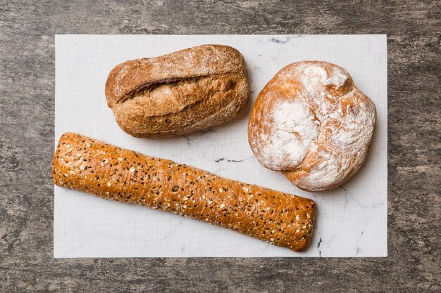 Assortment of freshly baked bread with napkin on rustic table top view Healthy unleavened bread French bread