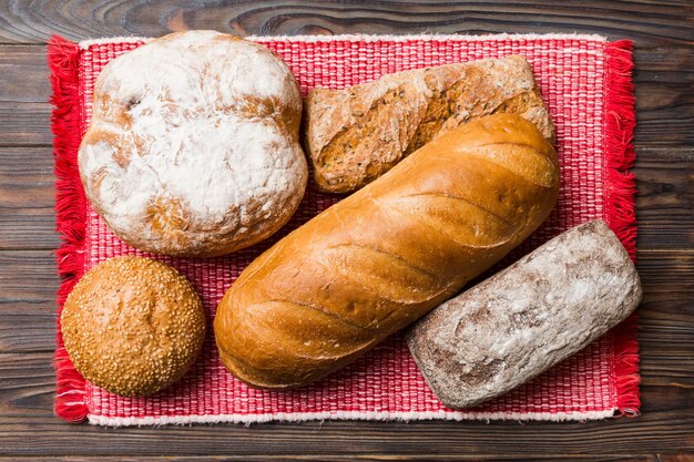 Assortment of freshly baked bread with napkin on rustic table\
top view healthy unleavened bread french bread