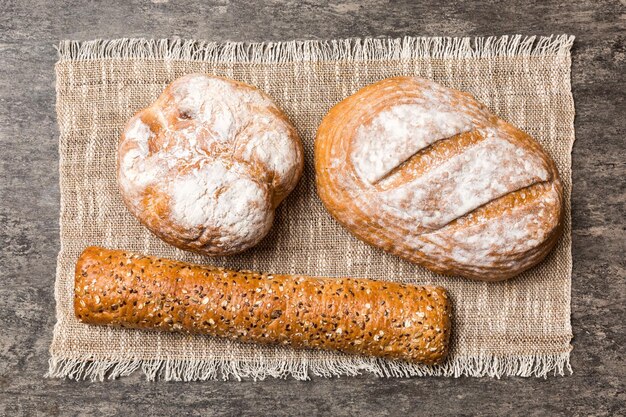 Assortment of freshly baked bread with napkin on rustic table top view Healthy unleavened bread French bread