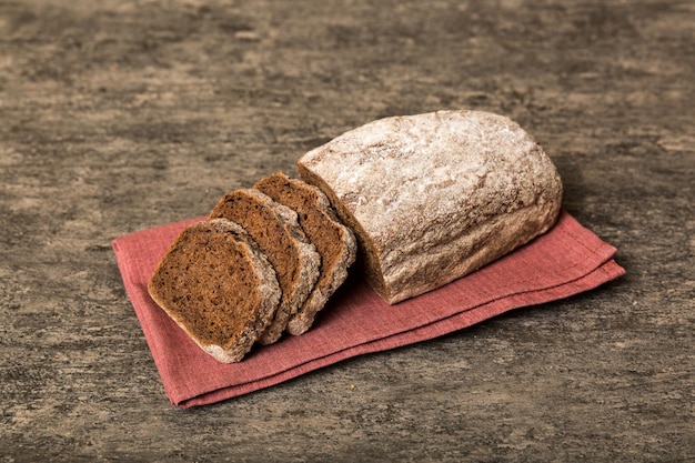 Assortment of freshly sliced baked bread with napkin on rustic table top view Healthy unleavened bread French bread slice