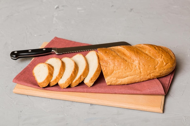 素朴なテーブルトップビューにナプキンとスライスしたての焼きたてのパンの品揃え健康的な種なしパンフランスのパンのスライス