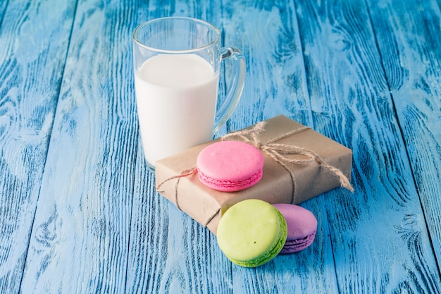 Assortment of gentle colorful macarons and glass with milk