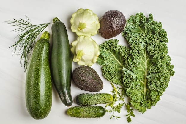 Assortment of green vegetables on white background, top view. 