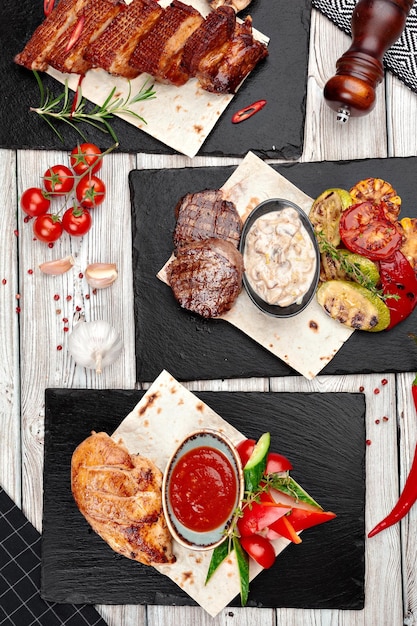 Assortment of grilled dishes on weathered wooden background