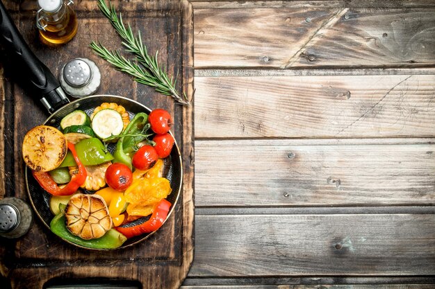 Photo assortment of grilled vegetables with a pan of herbs and spices on a cutting board