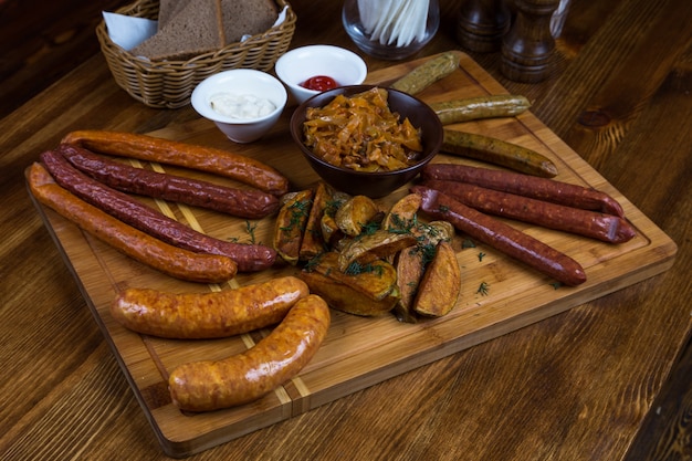 Assortment hot sausages serving on wooden board