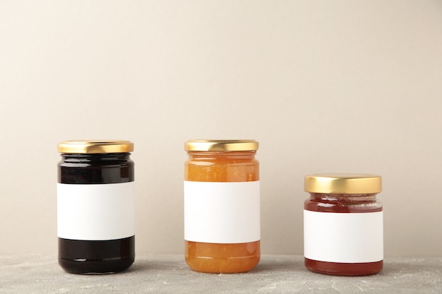 Assortment of jam jars mock-up. Jars with blank label on grey. Top view