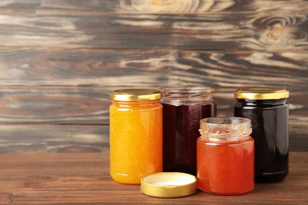 Assortment of jams on brown background with copy space.