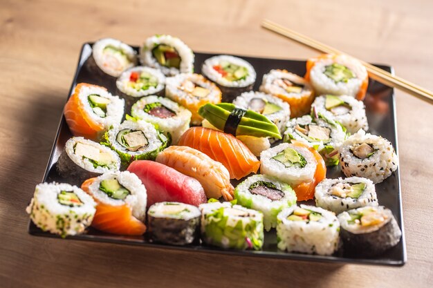 Assortimento di involtini di sushi giapponesi nigiri sashimi e maki.