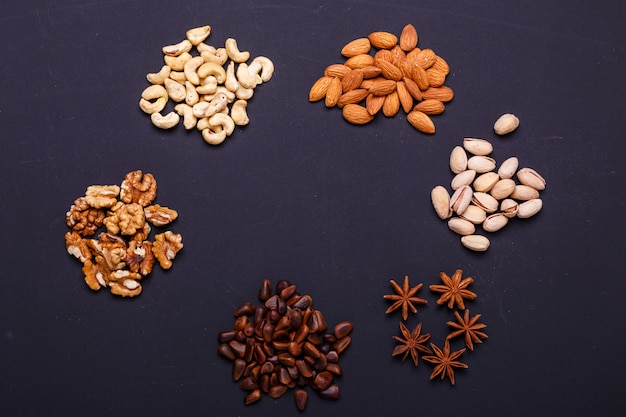 Assortment of nuts on a black slate - healthy snack.