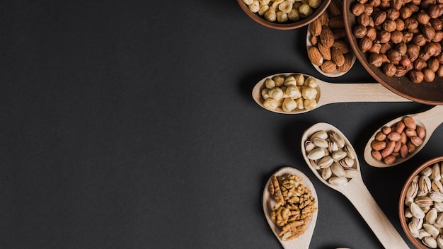 Assortment of nuts in spoons and bowls