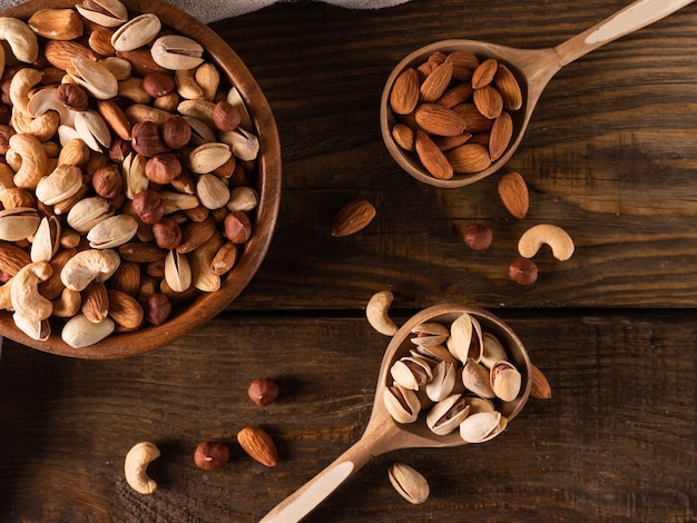 Assortment of nuts in wooden bowl on dark wooden table