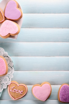 Assortimento di biscotti rosa d'amore sulla superficie del tavolo in legno blu, spazio copia