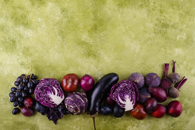 Assortment of purple vegetables on green background