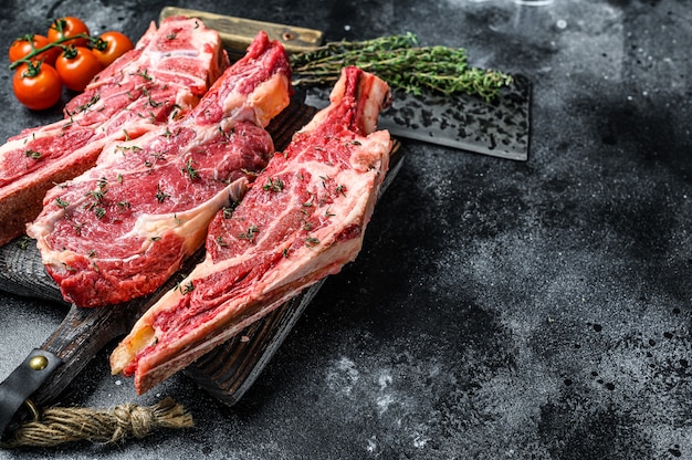 Assortment of raw cuts beef meat steaks on the bone.