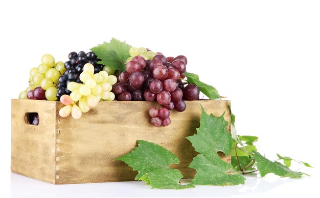 Photo assortment of ripe sweet grapes in wooden crate isolated on white