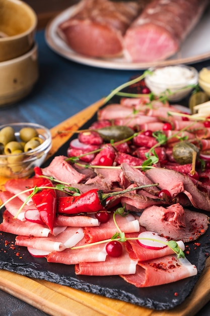 Assortment of salami and snacks on wooden board. Ham , salami, sausages and prosciutto on wooden board