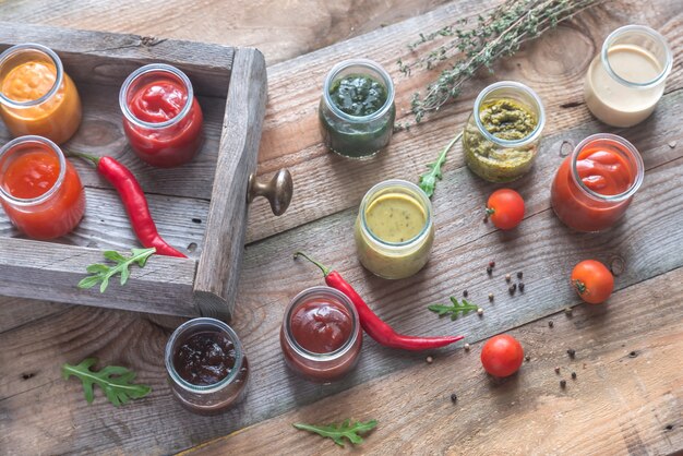 Assortment of sauces in the glass jars with ingredients