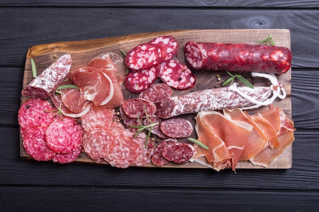 Assortment of sausages Ham salami and jamon on wooden board