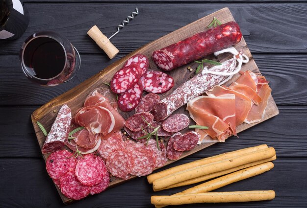 Assortment of sausages Ham salami and jamon on wooden board