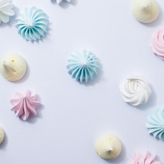 Assortment of small colorful meringue cookies on white