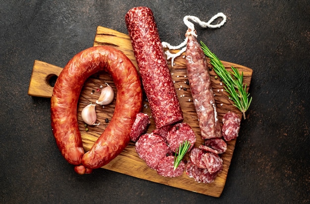 Assortment of smoked sausages and sausages with mold on a stone table