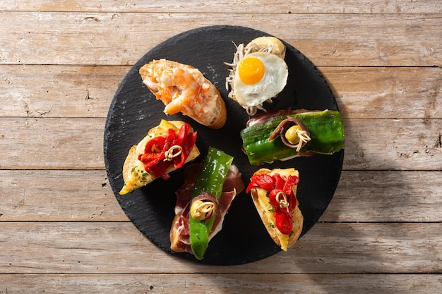 Assortment of Spanish pintxos on wooden table Typical spanish food