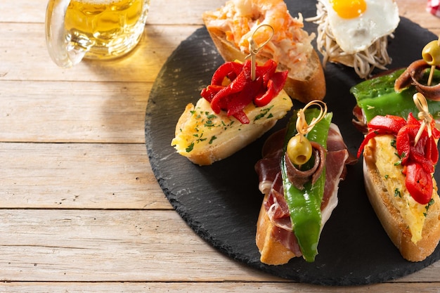 Assortment of Spanish pintxos on wooden table Typical spanish food