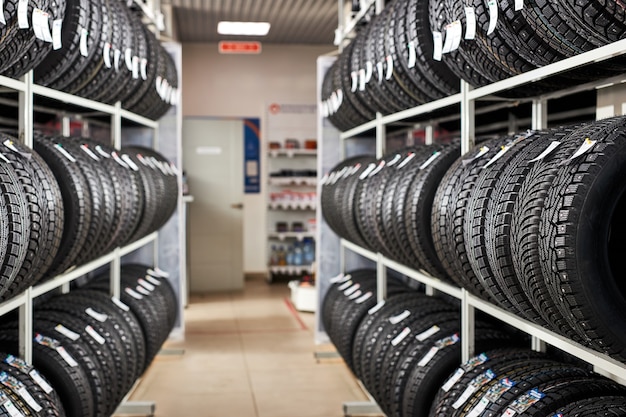 Assortment of tires for car in repair garage, replacement of winter and summer tires. seasonal tire replacement concept.