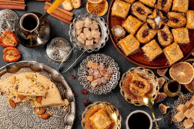 Assortment of turkish baklava on black textured surface