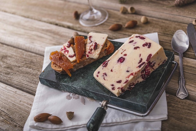 An assortment of various types of cheese with wine and grapes shot from above on a dark rustic background with a place for text square photo