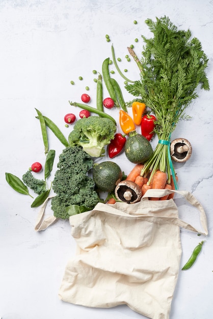 Assortment of vegetables coming out of an organic cloth bag