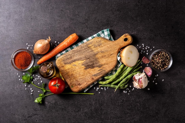 Assortment of vegetables herbs and spices on black background Top view Copy space