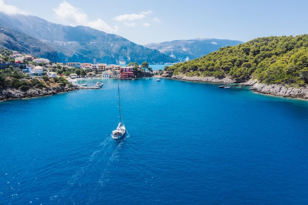 Assos picturesque fishing village from above Kefalonia Greece Aerial drone view Sailing boats moore