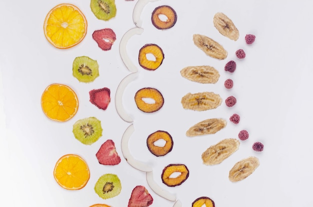 Assprtied dried fruits, chips scattered on white background. Fruit chips. Healthy eating concept, snack, no sugar. Top view, copy space.