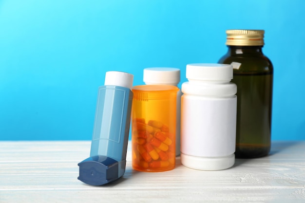 Asthma inhalers with medicines on blue background