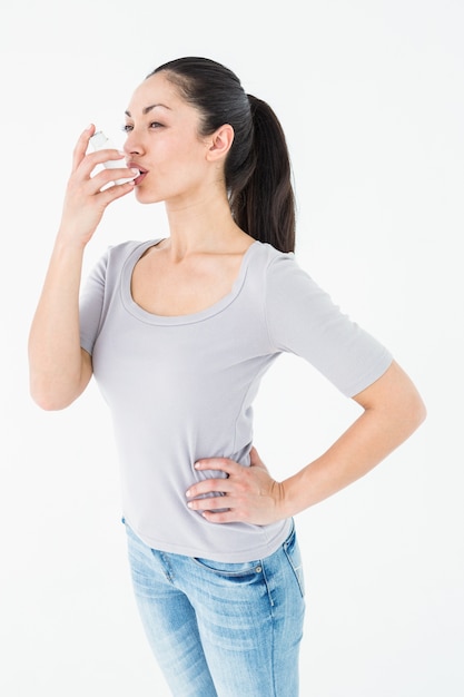 Photo asthmatic pretty brunette using inhaler