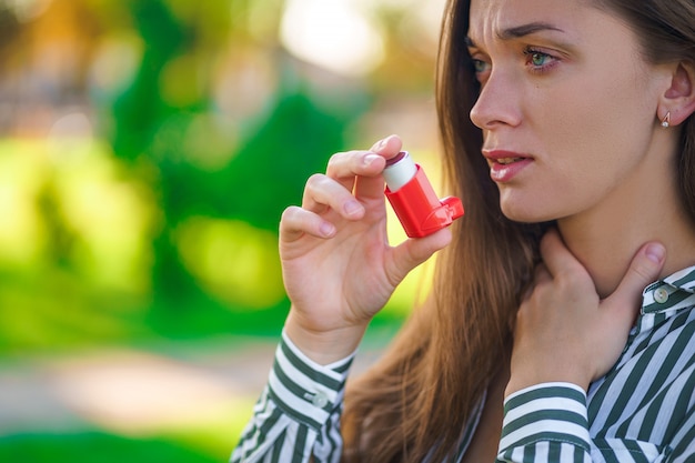 Asthmatic using inhaler from an asthma attack and suffocation outdoor