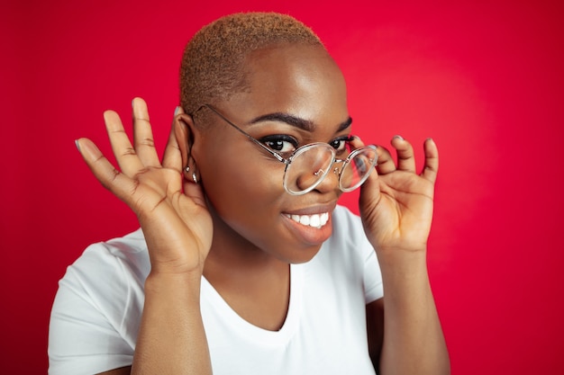 Astonished Africanamerican young womans portrait on red background