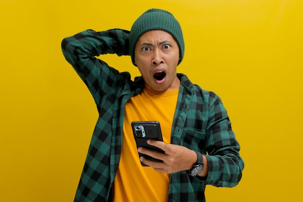 驚いたアジア人男性が携帯電話での電子商取引の特別オファー割引に驚いて反応します