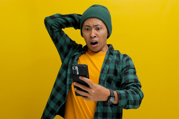 驚いたアジア人男性が携帯電話での電子商取引の特別オファー割引に驚いて反応します