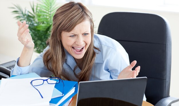 Astonished businesswoman looking at the laptop