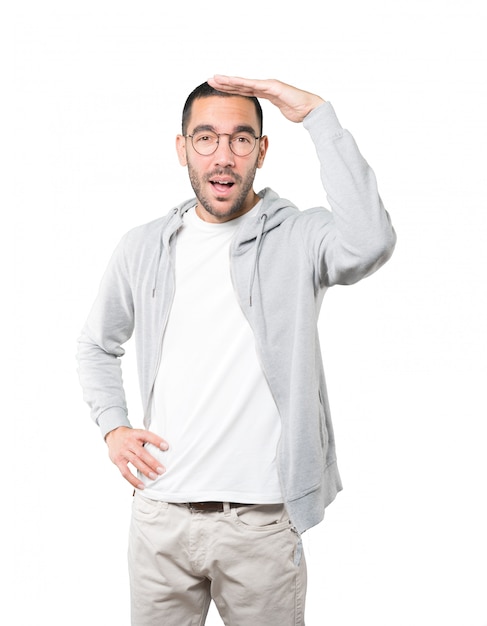 Astonished young man with a gesture of looking away