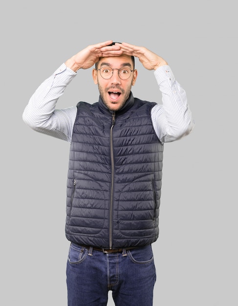 Astonished young man with a gesture of looking away