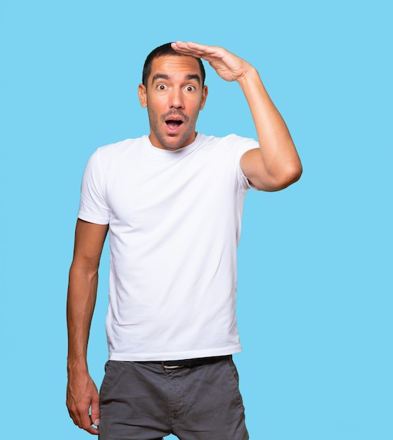 Astonished young man with a gesture of looking away