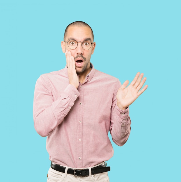 Astonished young man with a gesture of shock