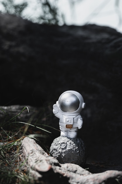 astronaut figurine stands among the stones